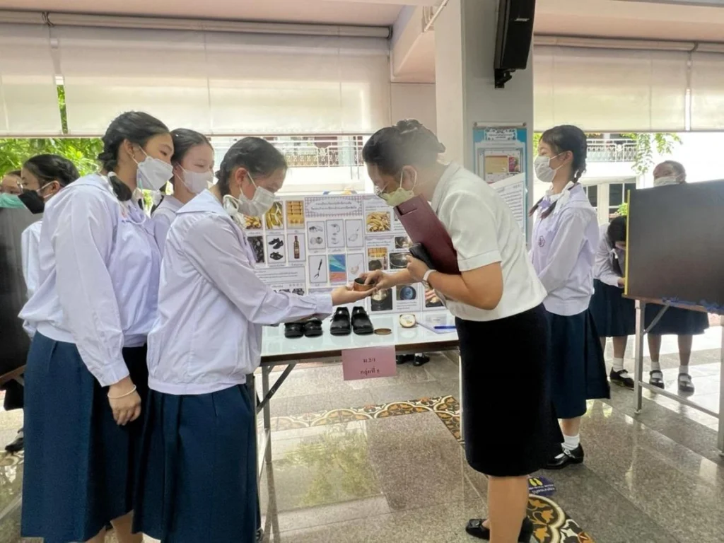 Teacher evaluating student science fair models and research projects